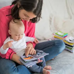 Mama z dzieckiem czyta książeczkę o samochodach. To idealny urlop na dziecko, pełen wspólnych chwil i nauki.