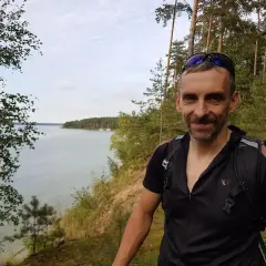 Uśmiechnięty rowerzysta na tle malowniczego zalewu sulejowskiego. Trasa rowerowa wokół zalewu sulejowskiego oferuje piękne widoki.