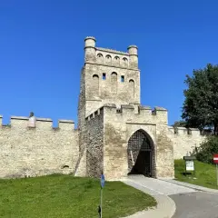 Kamienna brama z wieżą, otoczona murami obronnymi, przypomina polskie Carcassonne.
