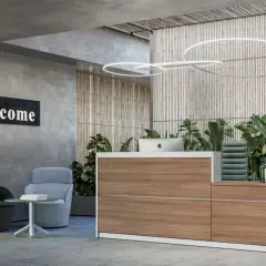 Accogliente reception con bancone in legno, piante rigogliose e un cartello "Welcome". Ideale per la gestione front office.