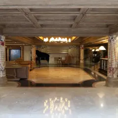 Eleganckie hotelowe lobby z fortepianem, kanapami i recepcją.