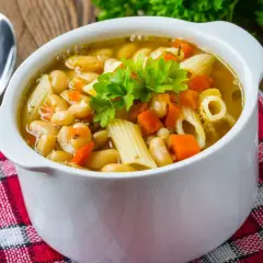 Pyszna zupa z makaronem, fasolą i marchewką, udekorowana natką pietruszki. Idealna na chłodne dni.