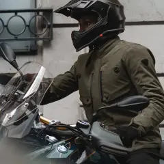 Motociclista con casco y chaqueta de aventura, que es Gore-Tex, lista para el viaje.