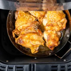 Pechuga de pollo dorada y jugosa cocinándose en una freidora de aire.