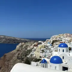 Widok na białe domy z niebieskimi kopułami na Santorini. Idealne miejsce na niezapomniane wycieczki.