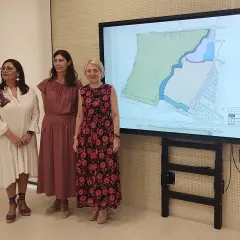 Tres mujeres observan un plano en pantalla grande, posiblemente sobre el proyecto **el toyo Almería**.