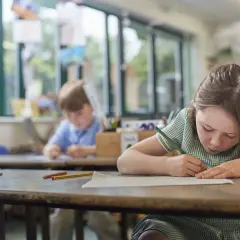 Dziewczynka w szkole rysuje, skupiona na pracy. Czy to zadanie od jakiej średniej jest 2?