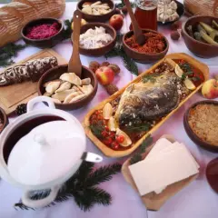 Wigilijny stół ugina się pod ciężarem potraw: karp, pierogi, kapusta, barszcz i inne przysmaki tworzą bogatą listę 12 potraw wigilijnych.