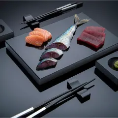 Sashimi-Zutaten: Lachs, Thunfisch, Makrele, Wasabi und Stäbchen. Die Frage "aus welchem Land kommt Sushi" führt uns nach Japan.