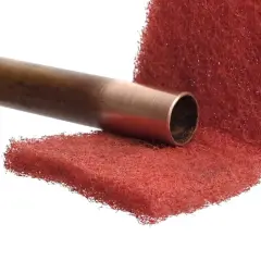 Miedziana rura przygotowana do lutowania aluminium z miedzią, na czerwonej druciance.