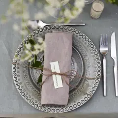 Vackert dukat bord med en lila servett vikt som en blomma, knuten med snöre. En liten lapp med texten "...when the weather is hot" sitter fäst.