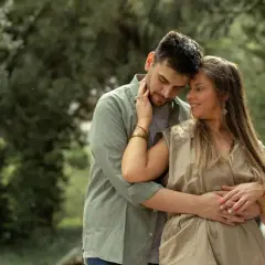Coppia abbracciata in un parco, un momento di tenerezza che racchiude il vero amore significato.