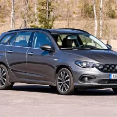 Grå Fiat Tipo kombi parkerad utomhus. En man sitter bakom ratten.