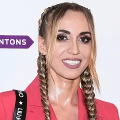 Marianna Schreiber kiedys, w różowej marynarce, z warkoczami i wyrazistym makijażem.