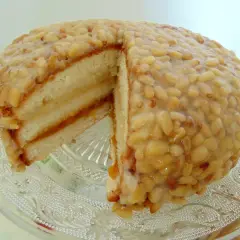Tarta de piñones tradicional, con capas de bizcocho y mermelada, cubierta de piñones caramelizados. ¡Un dulce irresistible!
