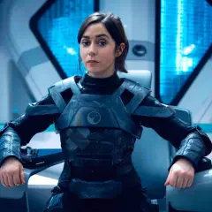 Une femme en armure futuriste, assise dans un cockpit, pourrait être un personnage de Black Mirror saison 7.