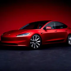 Un Tesla Model 3 rojo brillante, listo para demostrar su bajo consumo.