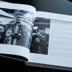 Mężczyzna z aparatem fotograficznym na szyi, w stroju z symbolem aparatu. Czy to on wynalazł fotografię?
