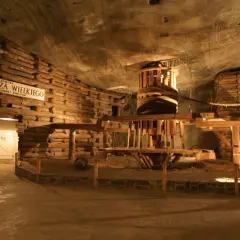 Wieliczka bilety grupowe: ekspozycja dawnej kopalni soli z drewnianą maszynerią i postacią górnika.