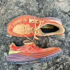 Kolorowe buty Hoka Speedgoat 6 na kamieniu. Hoka to firma znana z amortyzacji i komfortu.