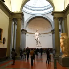 Beeld van David, een meesterwerk uit de renaissance periode, in een museum met bezoekers.