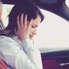 Donna in auto si tappa le orecchie per il fastidioso cigolio macchina.