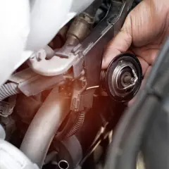 Mano che rimuove la valvola termostatica, forse perché non chiude bene e causa problemi al motore.