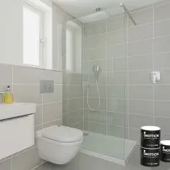 Bagno moderno con piastrelle grigie, doccia a filo pavimento e due barattoli di pittura per piastrelle.