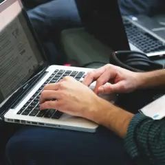 Osoba pisze na laptopie, szukając informacji, jak zmienić rozszerzenie pliku.