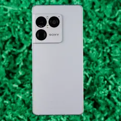 Srebrny smartfon Sony Xperia 1 VIII z potrójnym aparatem Zeiss na zielonym tle.