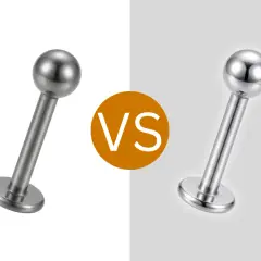 Dwa kolczyki do piercingu, jeden matowy, drugi błyszczący. Czy tytan to metal? Tak, jest.