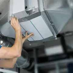 Installatör byter filterduk i ventilationssystem. Ren luft är viktigt för hälsan.