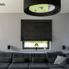 Elegancka roleta rzymska do salonu, wykonana z ciemnego materiału, tworzy przytulną atmosferę.