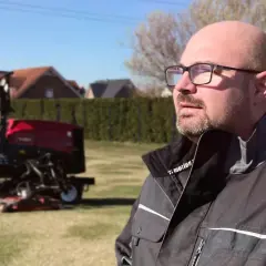 Mann mit Brille, der auf Rasenmäher blickt. Neue Wege für Quereinsteiger in Berufe in der Natur.