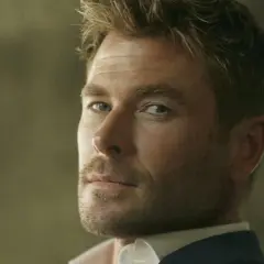 Hombre con corte low fade, barba cuidada y mirada intensa.