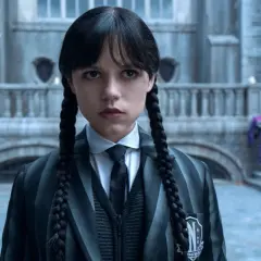 Mercredi Addams, prête pour la saison 2, fixe l'objectif avec son regard intense. L'uniforme de Nevermore Academy est impeccable.