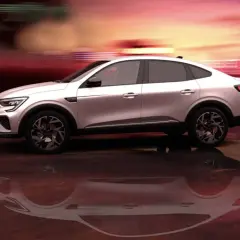 Białe Renault Arkana na tle rozmytego, czerwono-pomarańczowego nieba. Sprawdź atrakcyjną renault arkana cena!