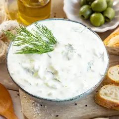 Cremiger Tzatziki mit Dill, serviert mit Baguette und Oliven. Ein einfaches Tzatziki Rezept für den Sommer.