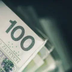 Stos banknotów 100 zł. Taki dodatek do przedszkola to marzenie wielu rodziców.