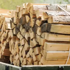 Stos drewna opałowego, pociętego na szczapy i związanego taśmami.