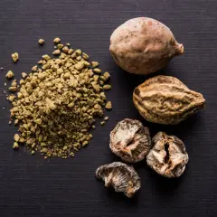 Getrocknete Früchte und Pulver von Triphala. Mögliche triphala nebenwirkungen sind selten, aber bei Einnahme zu beachten.