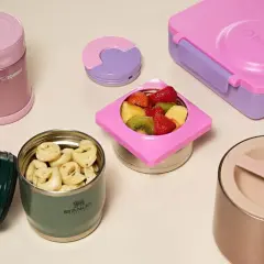 Colorful bento boxes and insulated food jars filled with pasta and fruit. These containers are designed to keep food warm for lunch.