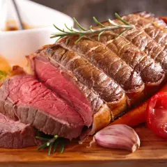Rosbeef parfaitement cuit, saignant et juteux, garni de romarin, carottes et ail. La cuisson rosbeef est un art.