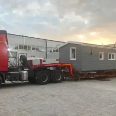 Ciężarówka transportuje gotowy dom modułowy. Sprawdź transport domu drewnianego w całości cena.