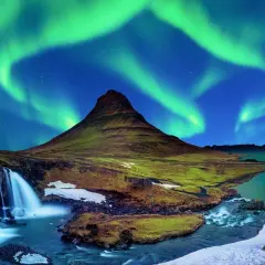 Góra Kirkjufell i wodospad pod zorzą polarną na Islandii.