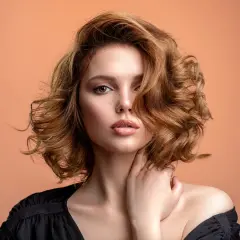 Mujer con pelo ondulado color cobre, un estilo que marca la tendencia pelo 2026.