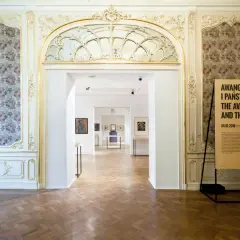 Wnętrze muzeum z tablicami informacyjnymi i widokiem na sale wystawowe.