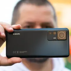 Dłoń trzyma czarny smartfon Xiaomi z widocznym modułem aparatów.