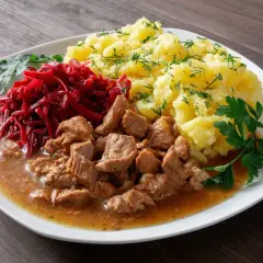 Pyszny gulasz z łopatki podany z ziemniakami i buraczkami.