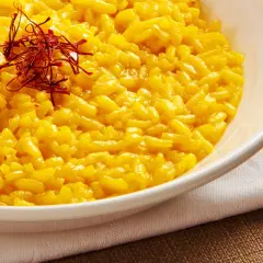 Aksamitne risotto alla milanese, bogato zdobione nitkami szafranu, kusi swoim złocistym kolorem i kremową konsystencją.